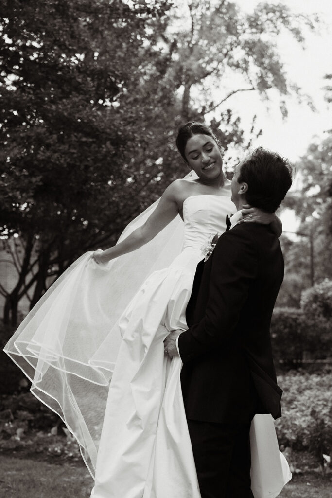 a groom picking up his bride as they pose for photos